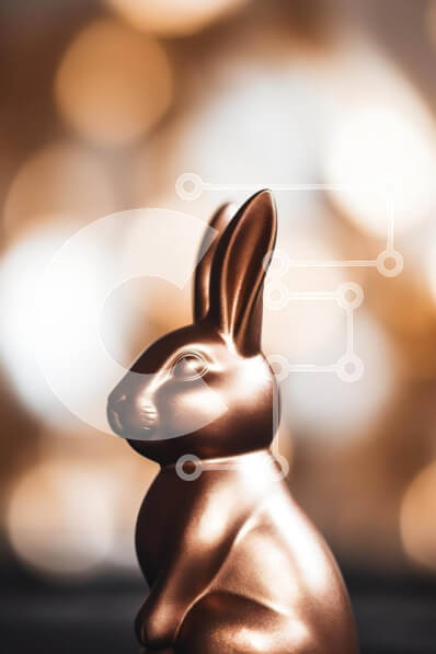 Intra Συλλεκτικό Ξύλινο Παζλ Plywood  4mm - Άγαλμα λαγουδάκι του Πάσχα με φόντο Bokeh Σε Ξύλινο Κουτί - Διαστάσεις Puzzle: 10x10 cm – 25 κομμάτια