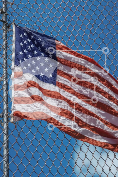 Intra Συλλεκτικό Ξύλινο Παζλ Plywood  4mm - Πατριωτικό υπόβαθρο με αμερικανική σημαία που κυματίζει στον άνεμο σε έναν φράκτη με κρίκους αλυσίδας Σε Ξύλινο Κουτί - Διαστάσεις Puzzle: 10x10 cm – 25 κομμάτια